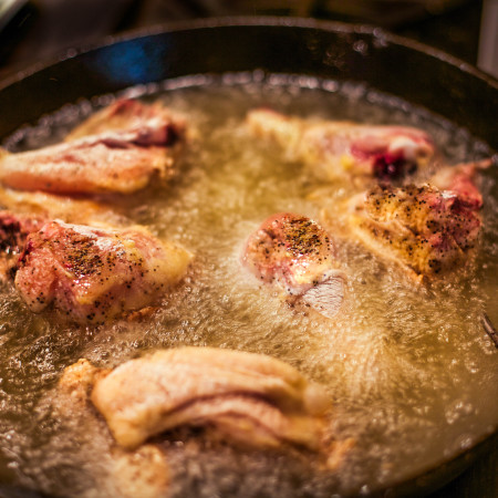 Peggy's Skillet Fried Chicken frying in a black iron skillet is a Cajun recipe and Cajun cooking at its best.