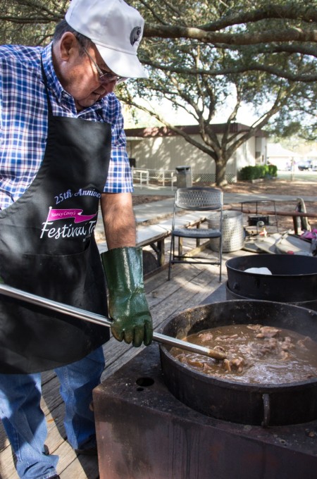 Stirring the Backbone Stew pot at the Eunice boucherie for a Cajun recipe of backbone stew.