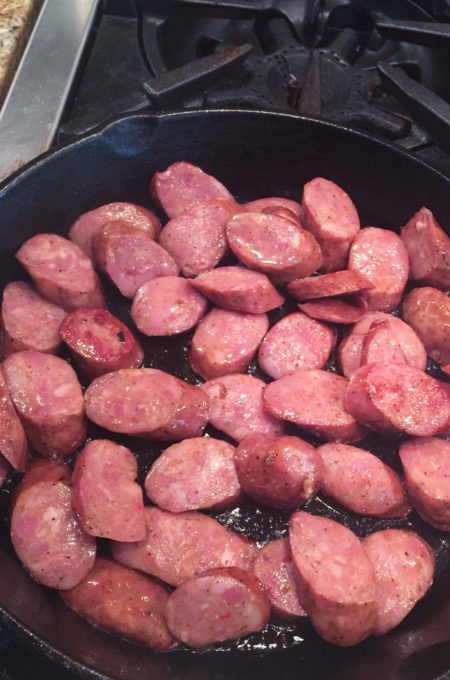 Smoked Pork sausage frying. Browning the sausage in bacon fat adds flavor.