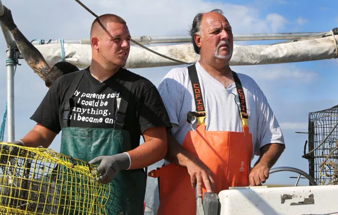 Timmy Luke (right) and his son Andi (left) fish the coastal waters for blue crabs. (Photo credit: Luke family archive)
